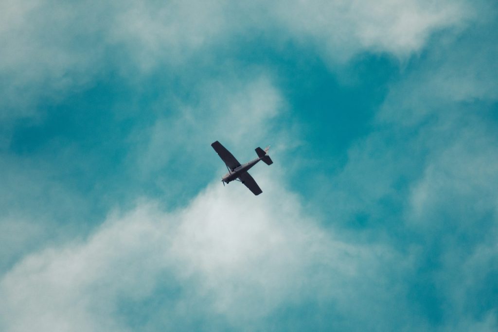 Un petit avion volant dans un ciel bleu nuageux