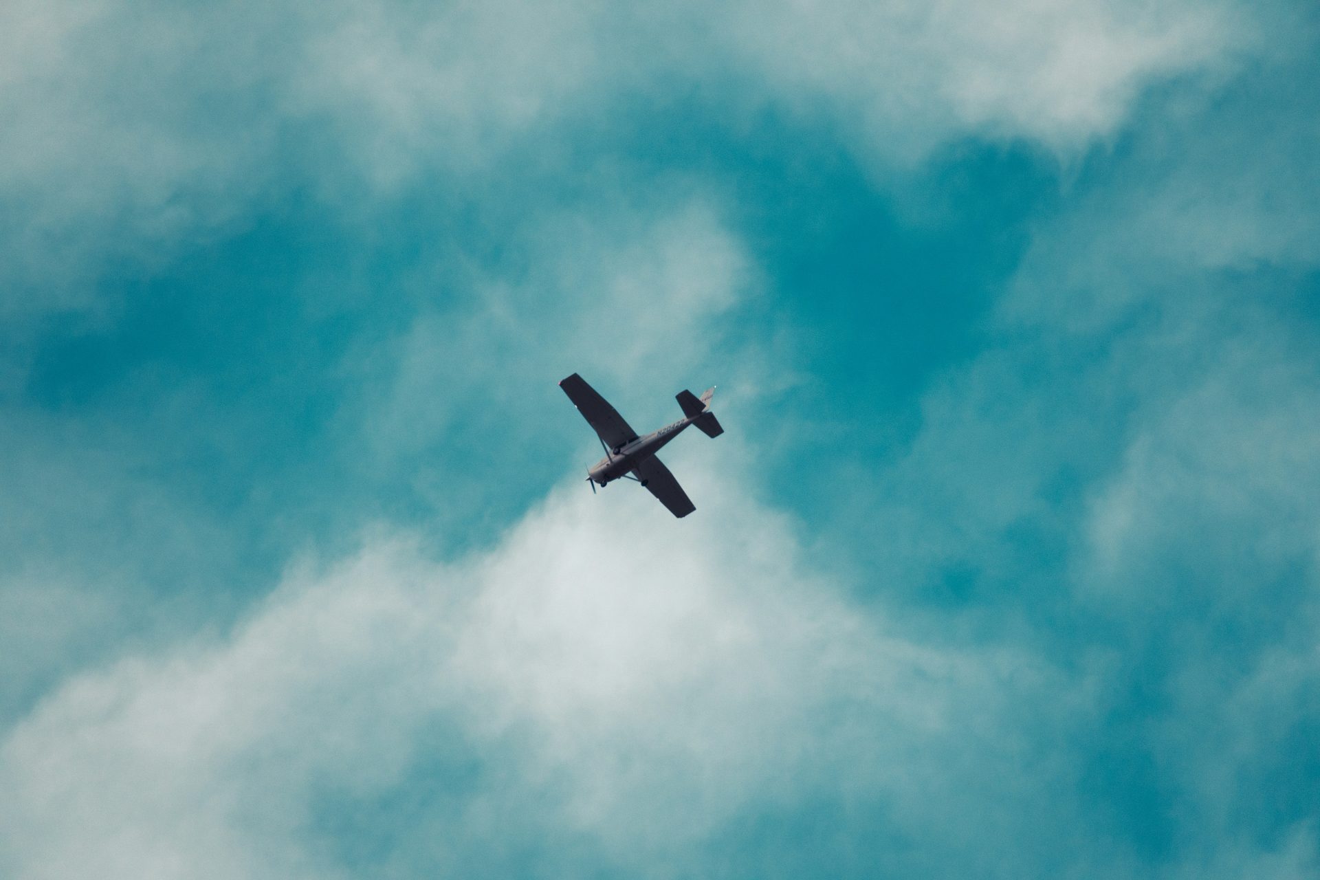 Un petit avion volant dans un ciel bleu nuageux